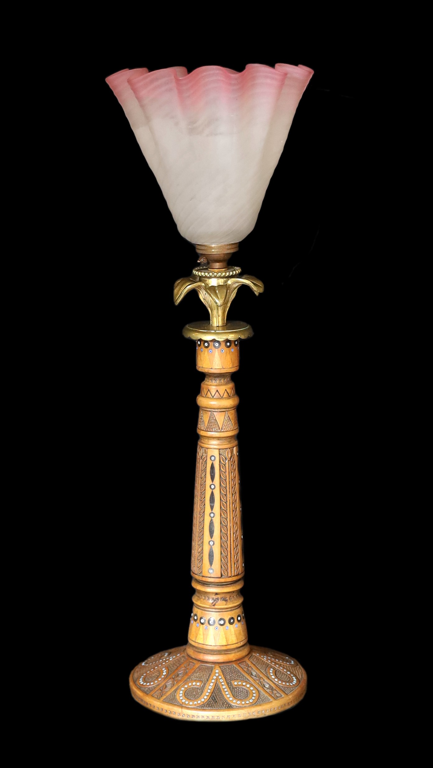 An early 20th century Danish carved and glass bead inset wood lamp base with brass flowerhead mount and associated tinted and frosted glass shade, height to top of shade 47cm